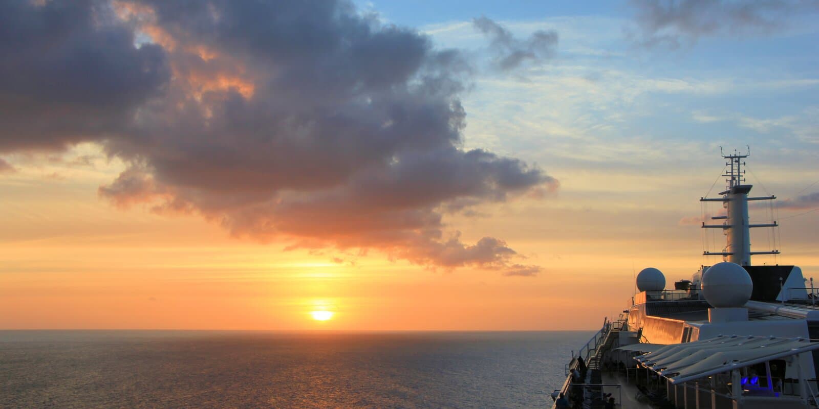 Large cruise ship at sunrise in the Caribbean with calm turquoise water